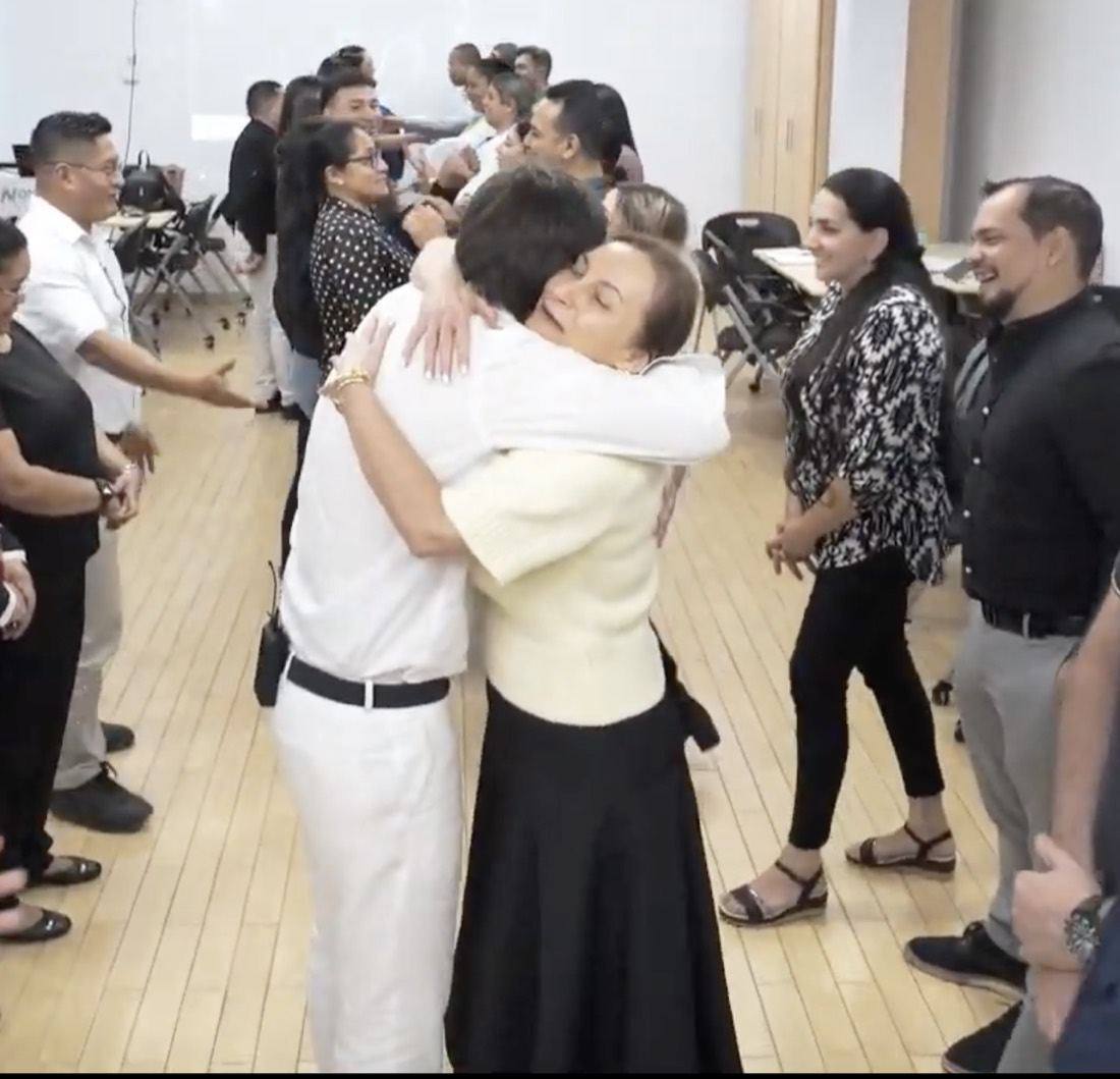 Dos líderes se abrazan, emocionados, rodeados de sus compañeros que aplauden